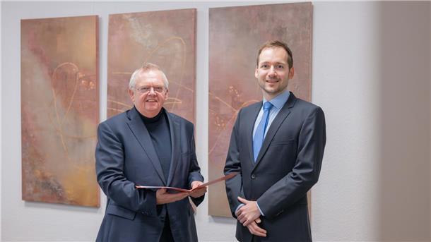Maximilian Charlet zum neuen Dezernenten für Bau ernannt Zwei Männer vor einer Wand Übergabe Ernennungsurkunde