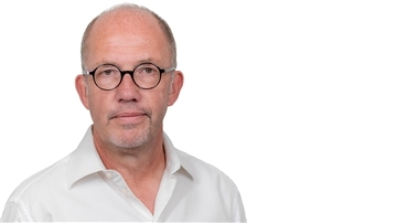 Mann in weißem Hemd mit Brille.