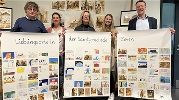 Vertreter der Samtgemeinde und der Schulen präsentieren die Plakate mit Motiven schönster Plätze.