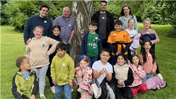 Eine Gruppe Kinder mit Begleitern hat sich zum Erinnerungsfoto aufgebaut.