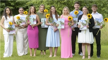 Sieben Frauen und zwei Männer haben sich zum Erinnerungsfoto aufgestellt. In den Händen hält jeder eine Urkunde und eine Sonnenblume.