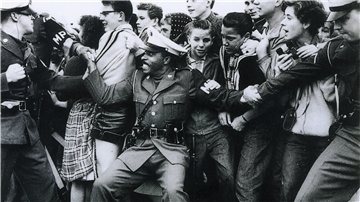 Zeitzeuge Rolf Hipper steht bei der Ankunft von Elvis Presley in Bremerhaven rechts hinter der Schulter des Militärpolizisten. 
