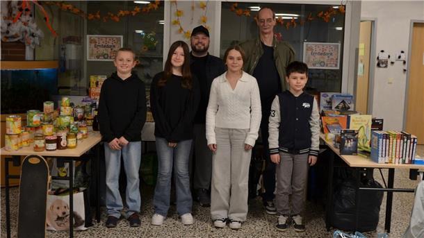 Schülerinnen und Schüler stehen vor Tischen mit Spenden 