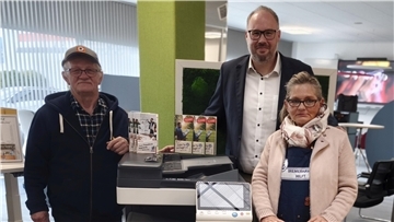 Drei Personen bei einer Spendenübergabe