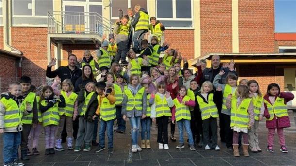 Bild von den Schülerinnen und Schülern der ersten Klasse der Grundschule Butjadingen mit Warnwesten vor dem Schulgebäude