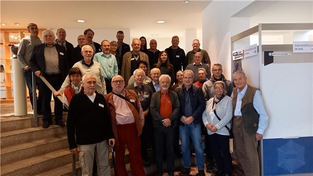 Eine Gruppe Menschen steht an, vor und auf einer Treppe