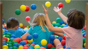 Kinder spielen in einem Bällebad.