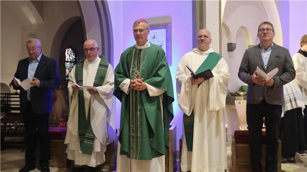 Fünf Männer, teilweise in Talaren. Sie sind im kirchlichen Kontext unterwegs.
