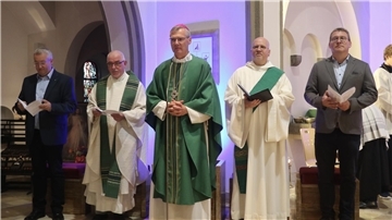 Fünf Männer, teilweise in Talaren. Sie sind im kirchlichen Kontext unterwegs.