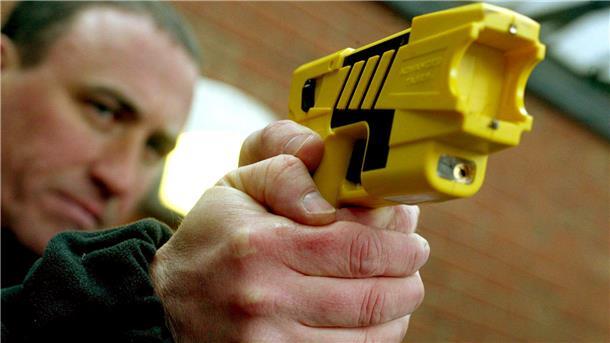 Polizist zielt mit Taser