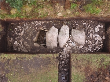 Blick auf eine archäologische Grabung mit freigelegten Steinen und Strukturen – ihre genaue Funktion wird im Rahmen der Untersuchung erforscht.