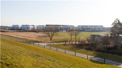 Blick vom Seedeich in Dorum-Neufeld: Auf der grünen Wiese zwischen den Siedlungsteilen im Vordergrund (rechts) und den Appartmenthäusern (links) soll das neue Hotel entstehen.