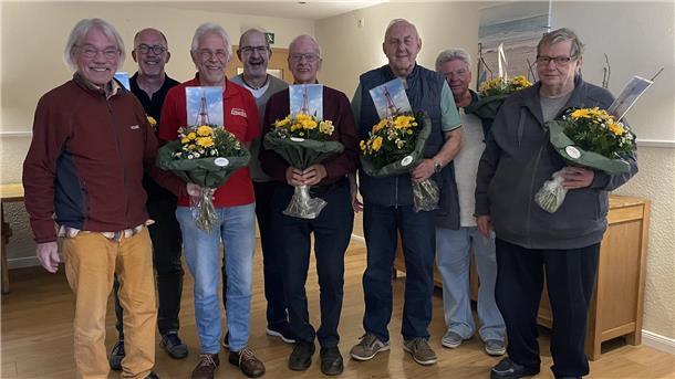 Eine Gruppe von Männern mit Blumensträußen. Die Mitglieder des Vorstands des Butjadinger Bürgerbus-Vereins wurden in ihren Ämtern bestätigt.