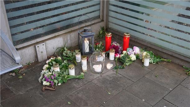 Blumen und Kerzen liegen auf dem Bahnsteig im Bahnhof von Brokstedt für die beiden Todesopfer.