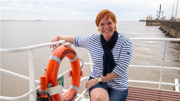 Eine Frau steht auf einem Schiff