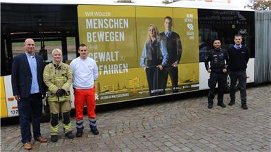Rettungskräfte stehen vor einem Bus.