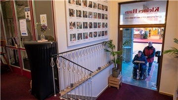 Eine Frau im Rollstuhl vor dem Stadttheater.