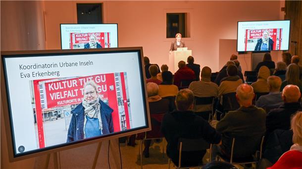 Stadt gibt Einblick: Das passiert aktuell in Bremerhavens Innenstadt Bürger-Dialog zur Zukunft der Bremerhavener Innenstadt im Auswandererhaus: Dorothee Starke gibt einen Ausblick am Pult, Eva Erkenberg ist auf dem Bildschirm zu sehen.