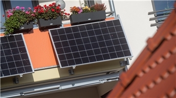Solarmodule für ein sogenanntes Balkonkraftwerk hängen an einem Balkon
