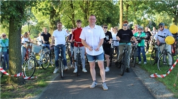 Bürgermeister Harald Hauschild durchschneidet symbolisch ein Band, um den Fahrradweg zwischen Seedorf und Godenstedt offiziell einzuweihen. 