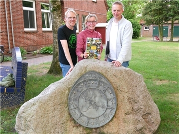 Bürgermeisterin Heidi Stelljes zwischen Florian Müller (links) und Holger Meyer freuen sich über die neu gestaltete Broschüre für den Bezirksentscheid „Unser Dorf hat Zukunft“.