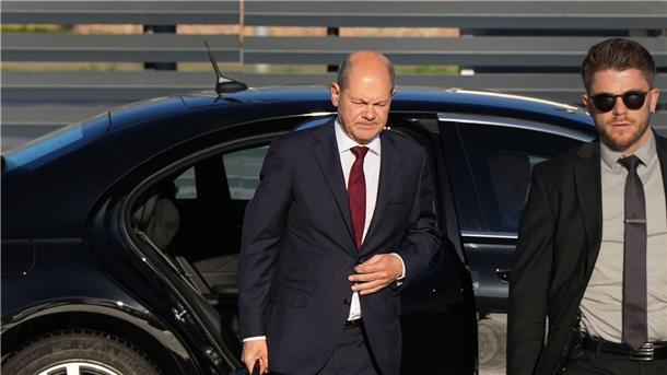 Bundeskanzler Olaf Scholz (l, SPD) kommt zum Start einer zweitägigen Reise auf dem militärischen Teil des Flughafens Berlin Brandenburg BER an und steigt aus einer Limousine.
