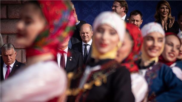 Bundeskanzler Olaf Scholz (M) beobachtet eine traditionelle Tanzvorführung beim Familienfoto beim EU-Westbalkan-Gipfel. Links ist Viktor Orban, Ministerpräsident von Ungarn, zu sehen.
