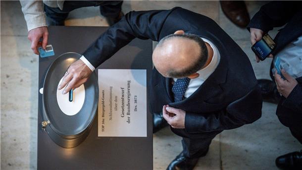 Bürgergeld-Reform: Auf Bundestag folgt Zitterpartie  Bundeskanzler Olaf Scholz (SPD), wirft seine Stimmkarte zum Bürgergeld im Bundestag ein.