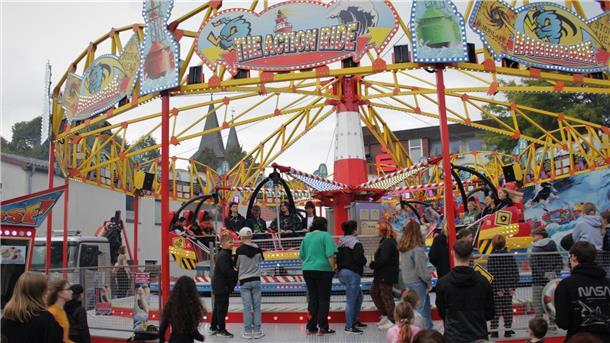 Menschen vor Fahrgeschäften  auf dem Herbstmarkt in Beverstedt.