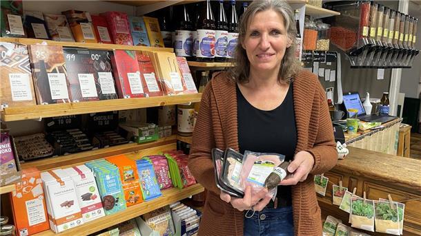 Frau im Bioladen mit Fleischwaren