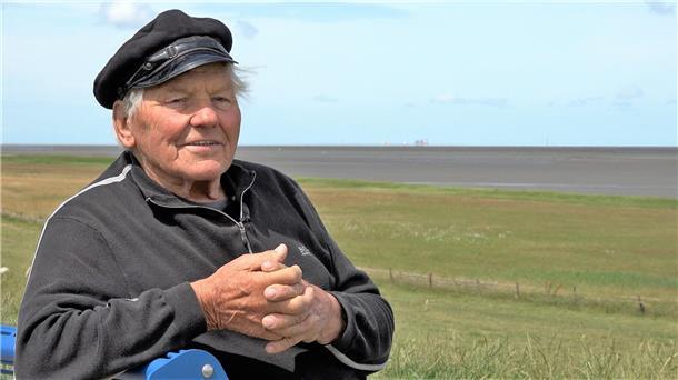 Ein alter Mann sitzt an der Butjadinger Küste auf einer Bank. Der Fedderwardersieler Altfischer Harry Thaden ist im Alter von 89 Jahren verstorben.