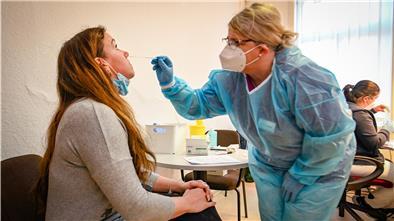 Carola Denker und Ebru Yeni (rechts hinten) testen Lehrerin Frauke Diercks in der Grundschule Hagen auf Corona-Viren.