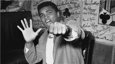 Cassius Clay, besser bekannt als Muhammad Ali, hält fünf Finger hoch, um vorauszusagen, wie viele Runden er brauchen wird, um Henry Cooper auszuknocken.