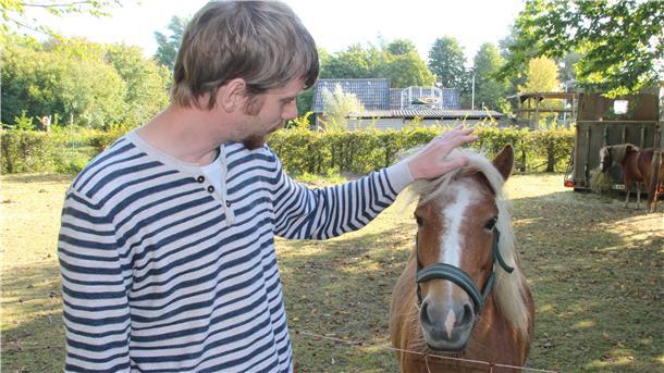 Ein Mann mit einem Pony.