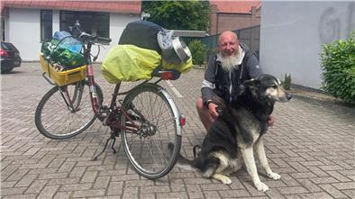 Warum Haustiere für viele wichtiger sind als Geld Ein Fahrrad, ein Mann, ein Hund.