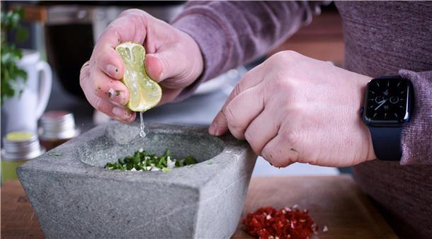 Simpel und saftig: Der „Deichgriller“ verrät sein perfektes Steak-Rezept Christian Schwarz presst eine ganze Limette über die Zutaten und zerreibt sie mit dem Mörser zu einem Brei. Dann folgen der Knoblauch und ein Schuss Olivenöl. Nach einer weiteren Runde im Mörser gibt der Grill-Influencer je einen Teelöffel rosa Himalaja-Salzflocken, Pfeffer, Oregano und Thymian hinzu. Noch einmal wird alles gemörsert, dann kommt die Chimichurri ins Einmachglas. Er füllt das Glas mit Olivenöl auf, bis die Paste gerade so bedeckt ist. Jetzt fehlt nur noch das Lorbeerblatt, dann ist die Steak-Sauce fertig.