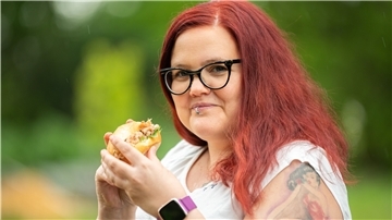 Christin Klever, Maschinenbauerin und Erfinderin einer neuen Krabbenpultechnik mit Ultraschall, steht mit einem Krabbenbrötchen in der Hand vor der Kamera. 
