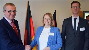 Zwei Männer und eine Frau stehen nebeneinander