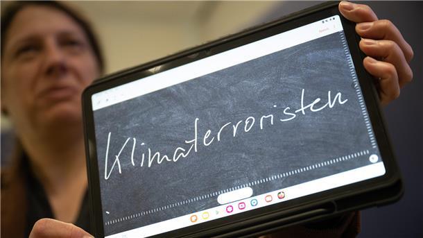 Constanze Spieß, Professorin am Institut für Germanistische Sprachwissenschaft der Philipps-Universität Marburg, hält ein Tablet in der Hand, auf dem das „Unwort des Jahres“ geschrieben steht.