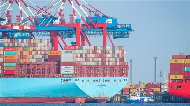 Containerschiff und Container in einem Hafen von Bremerhaven. Containerumschlag im Hafen: Laut dem Konjunkturbericht der Handelskammer Bremen – IHK für Bremen und Bremerhaven zeigt sich die Wirtschaftslage in Bremerhaven stabiler als in der Stadt Bremen.