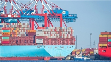 Containerschiff und Container in einem Hafen von Bremerhaven. Containerumschlag im Hafen: Laut dem Konjunkturbericht der Handelskammer Bremen – IHK für Bremen und Bremerhaven zeigt sich die Wirtschaftslage in Bremerhaven stabiler als in der Stadt Bremen.