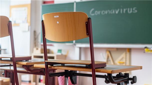 „Coronavirus“ steht auf einer Tafel in einem leeren Klassenzimmer.