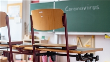 „Coronavirus“ steht auf einer Tafel in einem leeren Klassenzimmer.