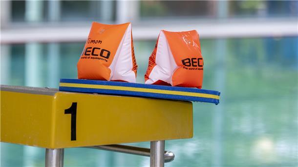 Magistrat unterstützt Sport- und Schwimmvereine bei gestiegenen Kosten Zwei Schwimmflügel und ein Schwimmbrett liegen auf einem Startblock
