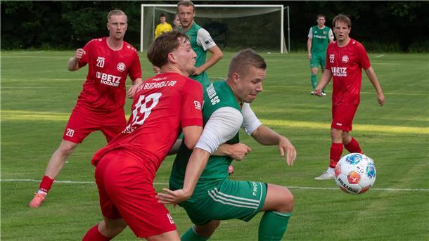 Zwei Männer in Sporttrikots kämpfen um einen Ball.