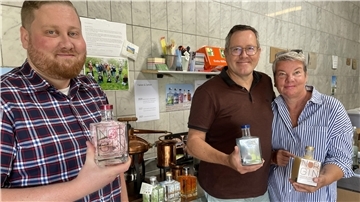 Zwei Männer und eine Frau mit Flaschen in der Hand. Daryn, Dirk und Birthe Vowinkel sind Norgin. Mit ihrem Gin haben sie eine erstaunliche Erfolgsgeschichte geschrieben.