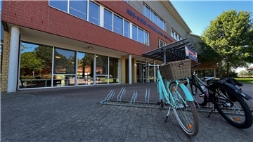 Ein Gebäude, davor stehen zwei Fahrräder. 