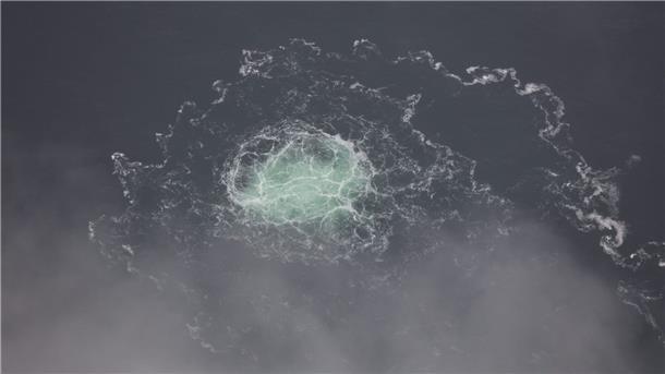 Das Bild zeigt ein kleines Gasleck bei Nord Stream 2 in der Ostsee, fotografiert aus einem Flugzeug der schwedischen Küstenwache.esamt vier Lecks in Nord-Stream-Leitungen“)
