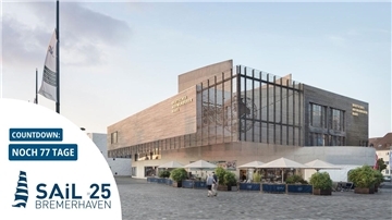 Ein Gebäude mit besonderen architektonischen Elementen. Davor ein Außenbereich mit Sonnenschirmen.