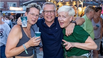 Zwei Frauen und ein Mann feiern beim Stadtfest 